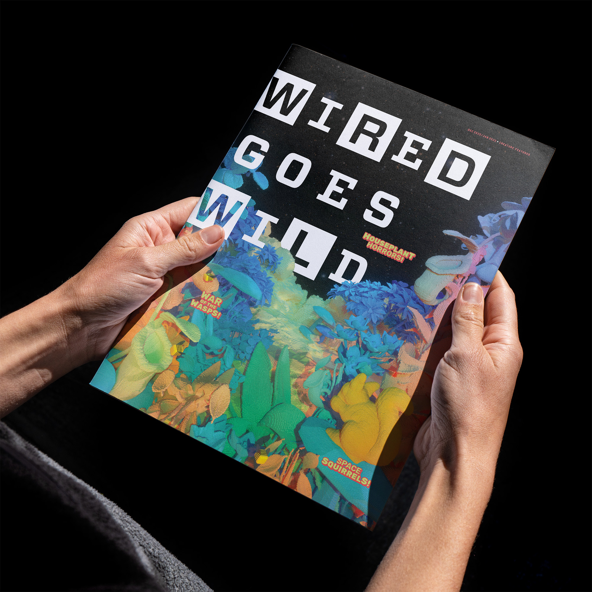 Hands holding a WIRED magazine against a black background.